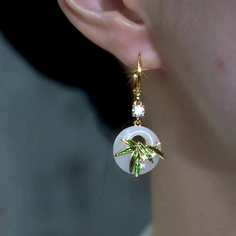 Model showcasing the dangle and style of the 14K Gold-Plated Elegant Zircon Bamboo Leaf Earrings