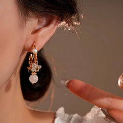 Model showcasing the dangle and style of the 14K Gold-Plated Elegant Zircon Bear Bead Star Tassel Earrings