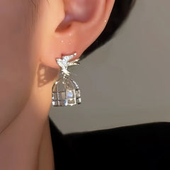 Model showcasing the dangle and style of the 14K Gold-Plated Elegant Zircon Birdcage Earrings