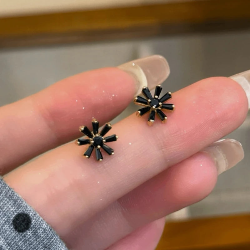 Model showcasing the dangle and style of the 14K Gold-Plated Elegant Zircon Black Sunflower Stud Earrings