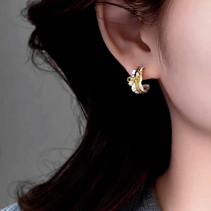 Model showcasing the dangle and style of the 14K Gold-Plated Elegant Zircon Bow C-Shaped Earrings