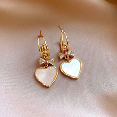Angled view of the 14K Gold-Plated Elegant Zircon Bow Shell Heart Earrings