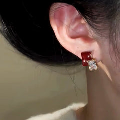 Model showcasing the dangle and style of the 14K Gold-Plated Elegant Zircon Burgundy Stud Earrings