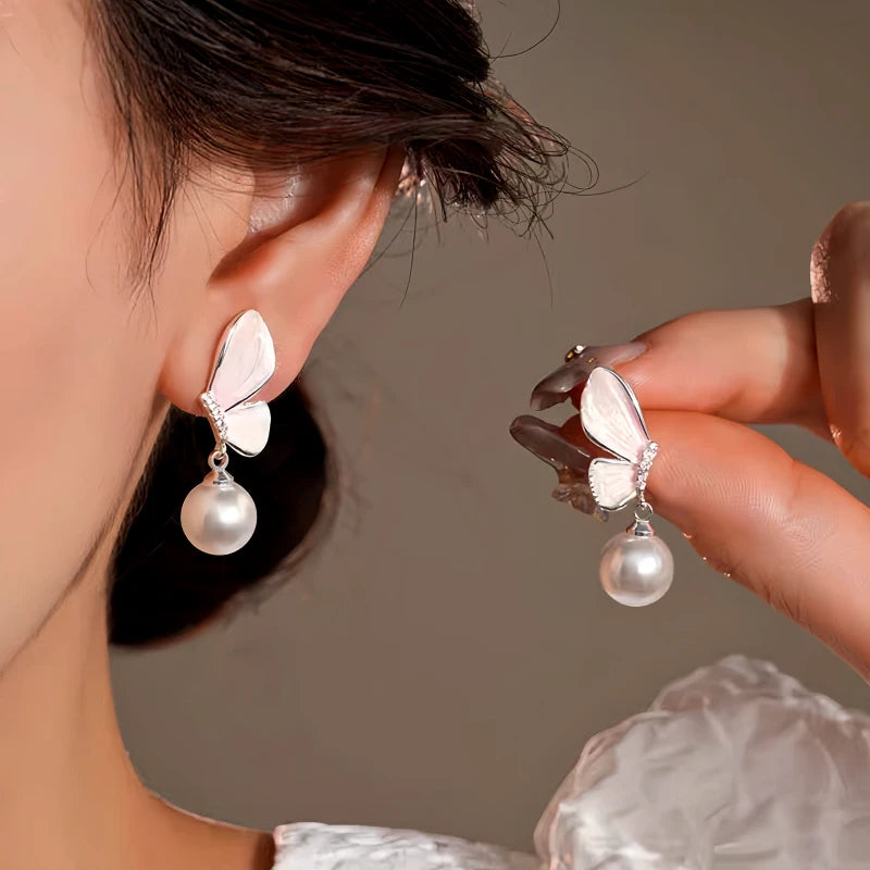 Model showcasing the dangle and style of the 14K Gold-Plated Elegant Zircon Butterfly Pearl Earrings