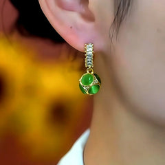 Model showcasing the dangle and style of the 14K Gold-Plated Elegant Zircon Cat's Eye Stone Ball Earrings