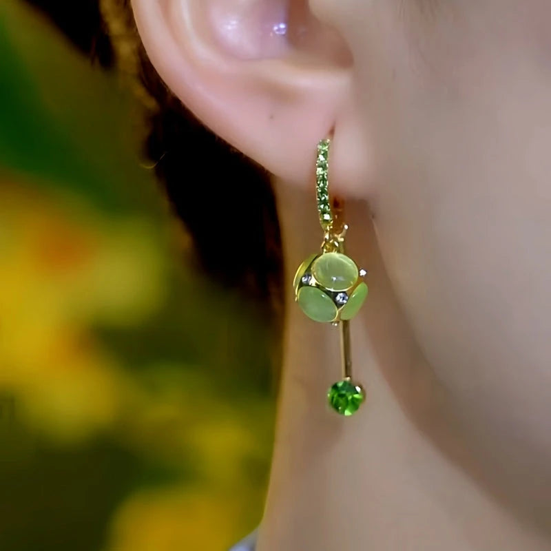 Model showcasing the dangle and style of the 14K Gold-Plated Elegant Zircon Cat's Eye Stone Ball Tassel Earrings