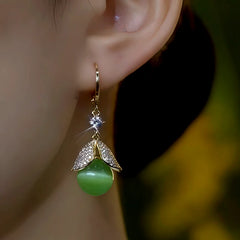 Model showcasing the dangle and style of the 14K Gold-Plated Elegant Zircon Cat's Eye Stone Bead Earrings