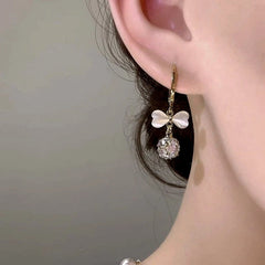 Close-up detail of the sparkling zircons and plating on the Cat's Eye Bow Earrings