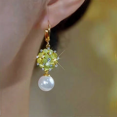Model showcasing the dangle and style of the 14K Gold-Plated Elegant Zircon Cat's Eye Stone Pearl Earrings