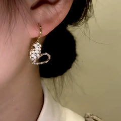 Model showcasing the dangle and style of the 14K Gold-Plated Elegant Zircon Diamond Flower Heart Earrings