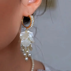 Model showcasing the dangle and style of the 14K Gold-Plated Elegant Zircon Diamond Flower Pearl Earrings