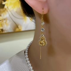 Model showcasing the dangle and style of the 14K Gold-Plated Elegant Zircon Diamond Gourd Threader Earrings