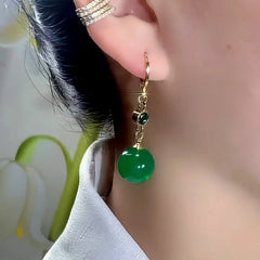 Model showcasing the dangle and style of the 14K Gold-Plated Elegant Zircon Diamond Green Bead Earrings
