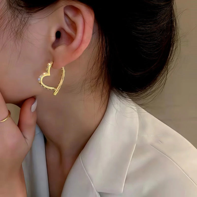 Model showcasing the dangle and style of the 14K Gold-Plated Elegant Zircon Diamond Heart Earrings