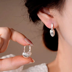 Close-up detail of the sparkling zircons and plating on the Gold Heart Earrings