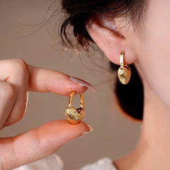 Model showcasing the dangle and style of the 14K Gold-Plated Elegant Zircon Diamond Heart Earrings