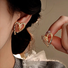 Model showcasing the dangle and style of the 14K Gold-Plated Elegant Zircon Diamond Heart Stud Earrings