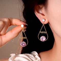 Angled view of the 14K Gold-Plated Elegant Zircon Diamond Love Letter Tassel Earrings