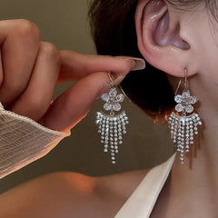 Model showcasing the dangle and style of the 14K Gold-Plated Elegant Zircon Diamond flower Tassel Earrings