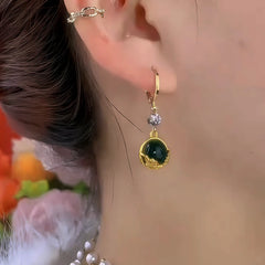 Model showcasing the dangle and style of the 14K Gold-Plated Elegant Zircon Diiamond Green Cat Eye Stone Earrings