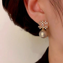 Model showcasing the dangle and style of the 14K Gold-Plated Elegant Zircon Double C Pearl Earrings