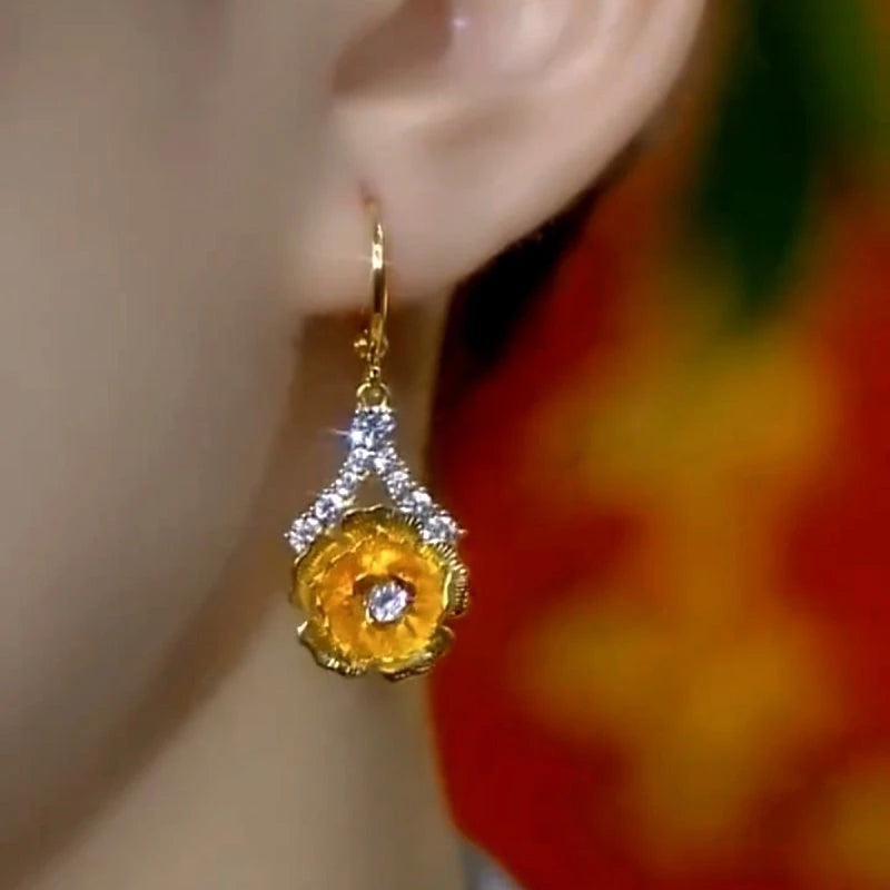 Model showcasing the dangle and style of the 14K Gold-Plated Elegant Zircon Flower Earrings