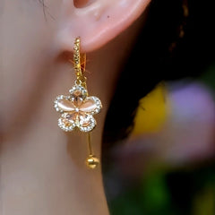 Close-up detail of the sparkling zircons and plating on the gold flower earrings