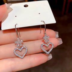 Model showcasing the dangle and style of the 14K Gold-Plated Elegant Zircon Flower Heart Ear Hooks