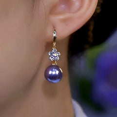 Model showcasing the dangle and style of the 14K Gold-Plated Elegant Zircon Flower Purple Pearl Earrings