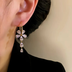 Model showcasing the dangle and style of the 14K Gold-Plated Elegant Zircon Flower Tassel Earrings