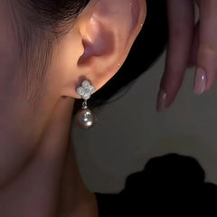 Close-up detail of the sparkling zircons and plating on the gold pearl earrings