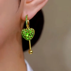 Close-up detail of the sparkling zircons and plating on the green heart earrings
