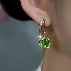 Model showcasing the dangle and style of the 14K Gold-Plated Elegant Zircon Gingko Leaf Bead Earrings