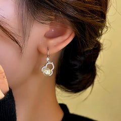 Model showcasing the dangle and style of the 14K Gold-Plated Elegant Zircon Gourd Bead Ear Hooks