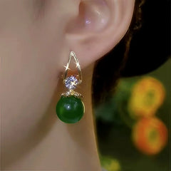 Model showcasing the dangle and style of the 14K Gold-Plated Elegant Zircon Green Bead Earrings