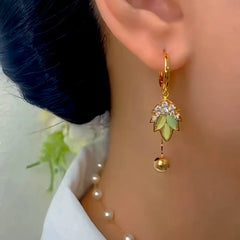 Model showcasing the dangle and style of the 14K Gold-Plated Elegant Zircon Green Cat's Eye Stone Leaf Tassel Earrings