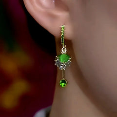 Model showcasing the dangle and style of the 14K Gold-Plated Elegant Zircon Green Cat's Eye Stone Tassel Earrings