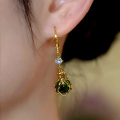 Model showcasing the dangle and style of the 14K Gold-Plated Elegant Zircon Green Diamond Cabbage Earrings