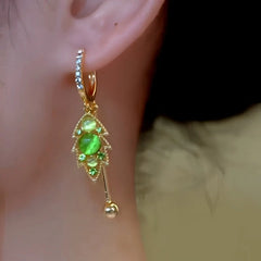 Model showcasing the dangle and style of the 14K Gold-Plated Elegant Zircon Green Diamond Cat's Eye Stone Leaf Tassel Earrings