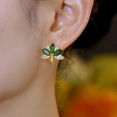 Model showcasing the dangle and style of the 14K Gold-Plated Elegant Zircon Green Diamond Leaf Stud Earrings