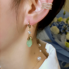 Model showcasing the dangle and style of the 14K Gold-Plated Elegant Zircon Green Magnolia Earrings