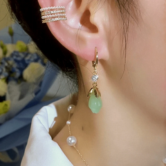 Close-up detail of the sparkling zircons and plating on the green flower earrings