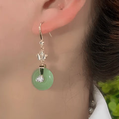 Model showcasing the dangle and style of the 14K Gold-Plated Elegant Zircon Green Round Peace Ear Hooks