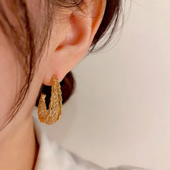 Model showcasing the dangle and style of the 14K Gold-Plated Elegant Zircon Grid Geometric Earrings