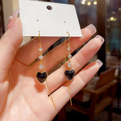 Model showcasing the dangle and style of the 14K Gold-Plated Elegant Zircon Heart-Design Tassel Threader Earrings