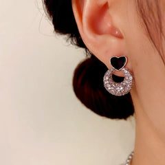 Model showcasing the dangle and style of the 14K Gold-Plated Elegant Zircon Heart Earrings
