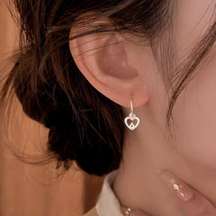 Close-up detail of the sparkling zircons and plating on the silver heart earrings
