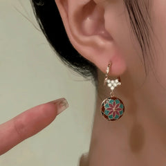 Close-up detail of the sparkling zircons and plating on the gold heart earrings