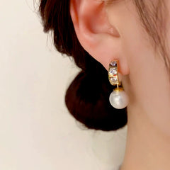 Close-up detail of the sparkling zircons and plating on the gold pearl earrings