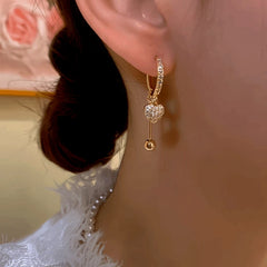 Close-up detail of the sparkling zircons and plating on the gold tassel earrings